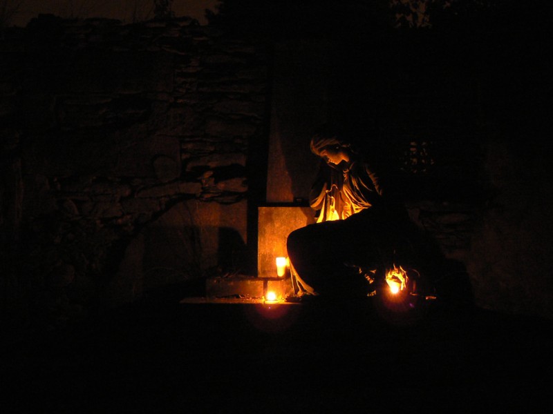 Nádherná socha dívky, ozářená svitem svíček